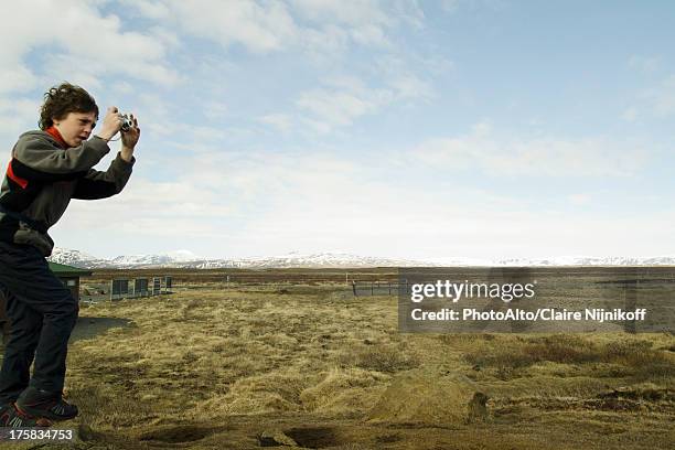 boy photographing the gullfoss landscape, iceland - photographe photos et images de collection