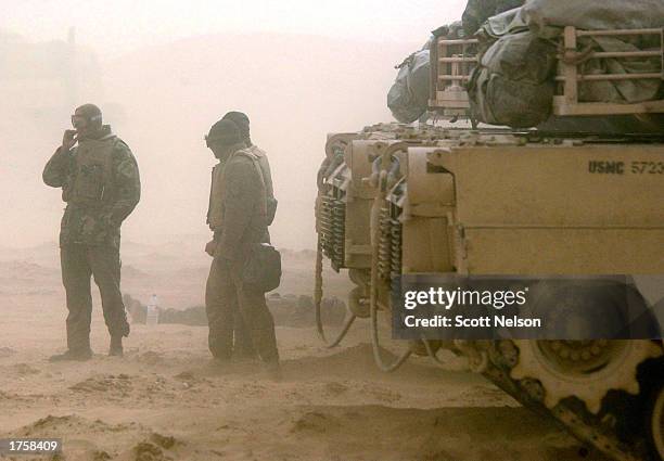 Marine Corps 1st Tank Battallion tank crews wait out a blinding sand storm during exercises February 3, 2003 near the Iraqi border in Kuwait. Both...