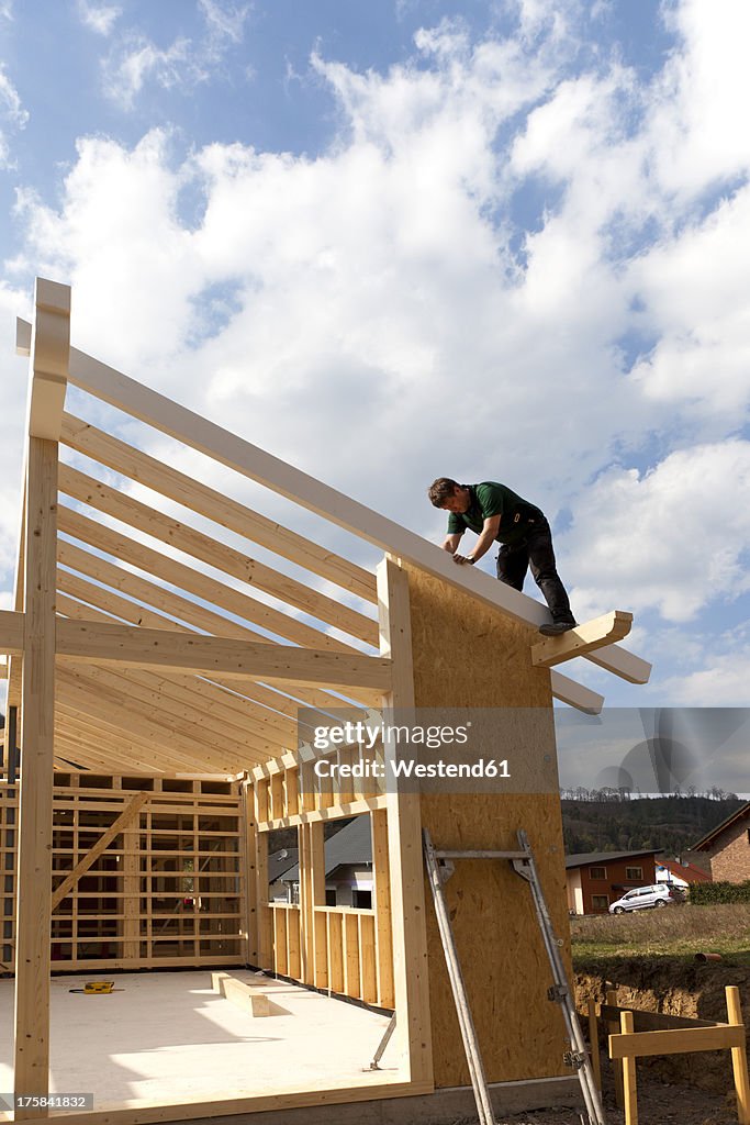 Europe, Germany, Rhineland Palantinate, Man installing and fixing wooden walls of prefabricated house