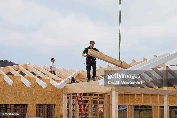 europe, germany, rhineland palatinate, men working on roof of house - roof truss stock pictures, royalty-free photos & images