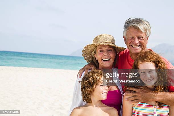 spain, grandparents with grandchildren having fun at beach, smiling - preteen girl no shirt stock pictures, royalty-free photos & images
