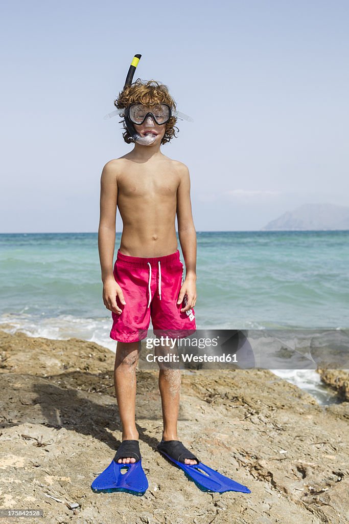 Spain, Boy with diving equipment on beach