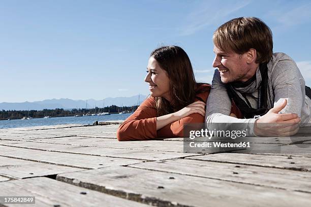 germany, bavaria, couple lying on jetty at lake starnberg - starnberger see stock-fotos und bilder