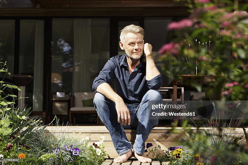 Germany, Berlin, Mature man relaxing on terrace, smiling