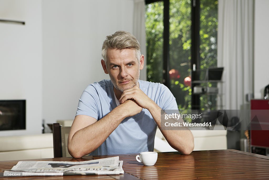 Germany, Berlin, Mature man sitting at table, portrait