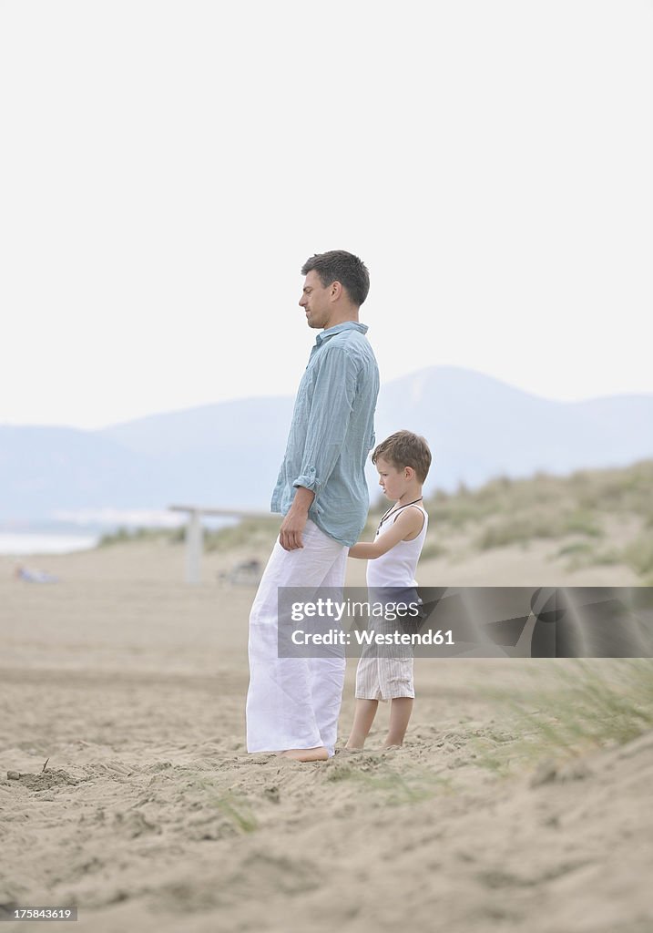 Germany, Father and son standing on beach