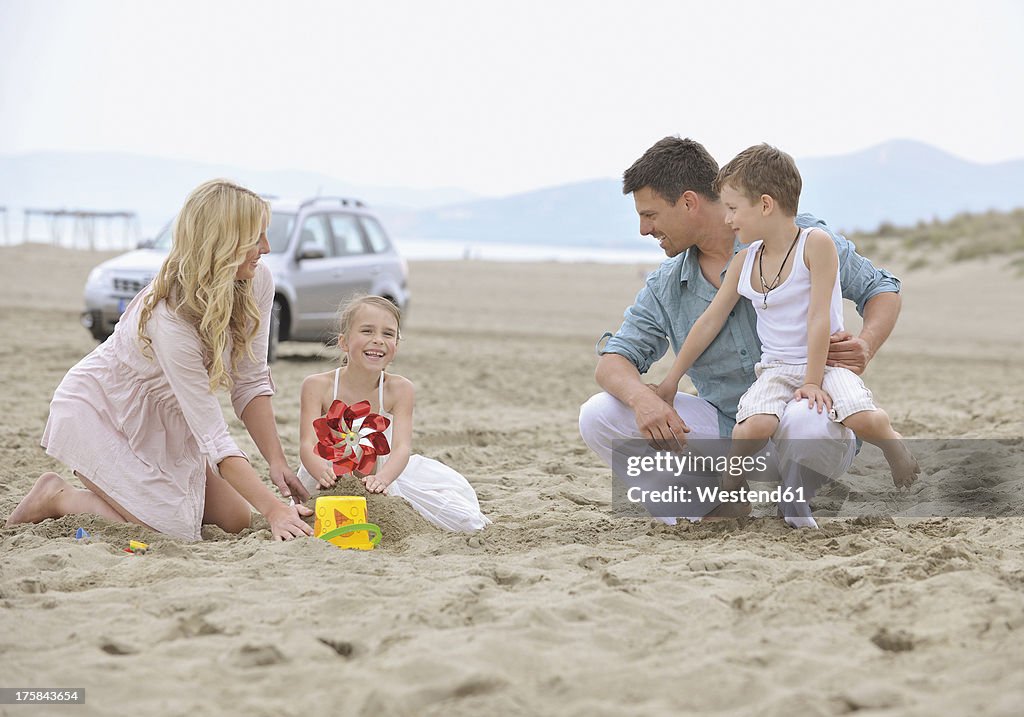 Spain, Family playing on beach, smiling