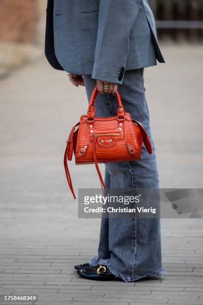 Marta Perez wears grey blazer, grey denim jeans, orange Balenciaga bag, laced top, flat shoes at day 3 of 080 Barcelona Fashion 2023 at Recinte...