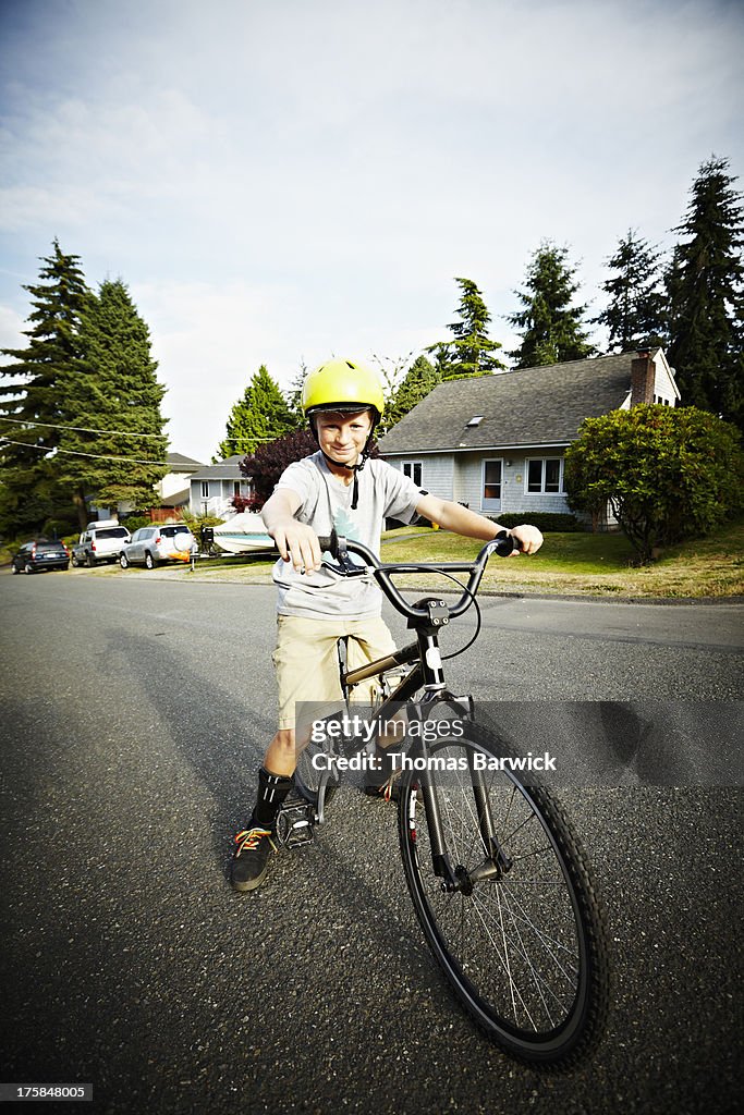 Portrait of young boy sitting on bike