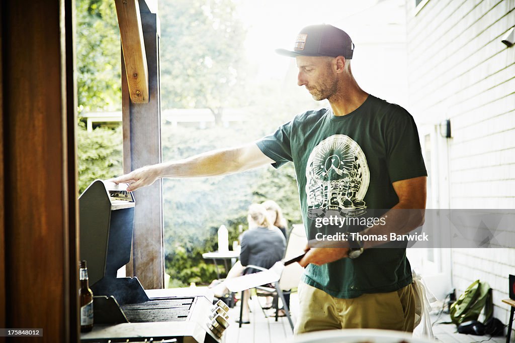 Father working on barbecue in backyard