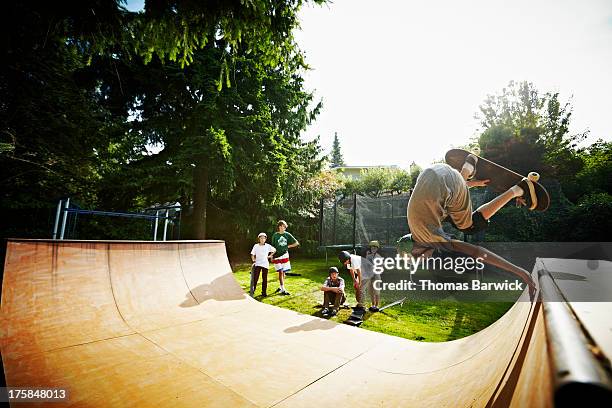 young male skateboarder inverted on halfpipe - half pipe stock pictures, royalty-free photos & images