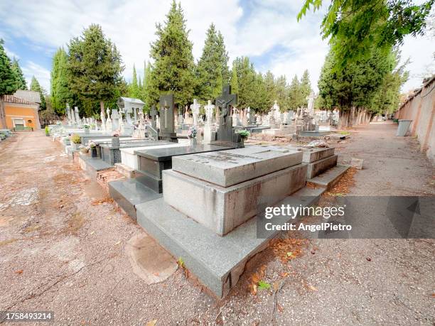 a traditional cemetery, with graves, paths, flower beds, cypresses... - funeral stock photos et images de collection