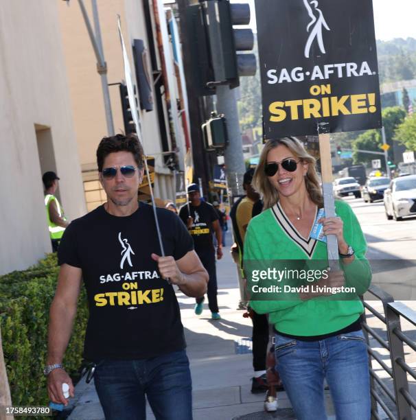 Michael Trucco and Tricia Helfer join the picket line outside Warner Bros. Studios on October 26, 2023 in Burbank, California. SAG-AFTRA has been on...