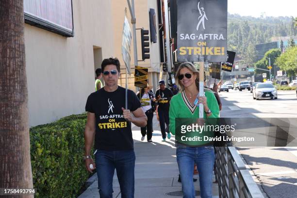 Michael Trucco and Tricia Helfer join the picket line outside Warner Bros. Studios on October 26, 2023 in Burbank, California. SAG-AFTRA has been on...