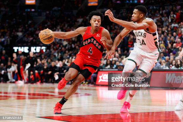Scottie Barnes of the Toronto Raptors drives to the net against Giannis Antetokounmpo of the Milwaukee Bucks during the first half of their NBA game...