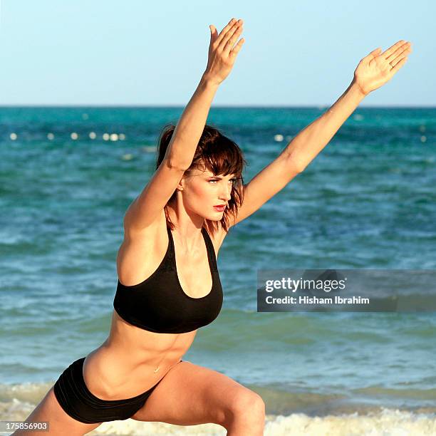 beautiful young woman practicing yoga on the beach - freeport bahamas stock pictures, royalty-free photos & images