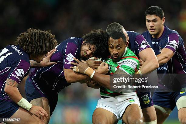 Roy Asotasi of the Rabbitohs is tackled during the round 22 NRL match between the Melbourne Storm and the South Sydney Rabbitohs at AAMI Park on...