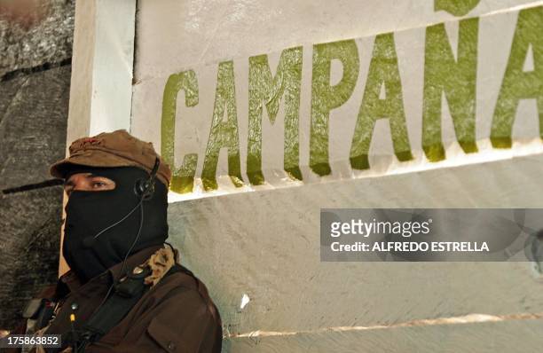 The leader of the Mexican Zapatista Army of National Liberation Subcomandante Marcos listens to a speaker during the EZLN plenary in La Garrucha...