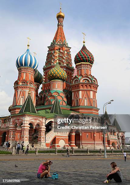 Onlookers pose for photos outsdie St. Basil's Cathedral ahead of the 14th IAAF World Championships at on August 6, 2013 in Moscow, Russia.