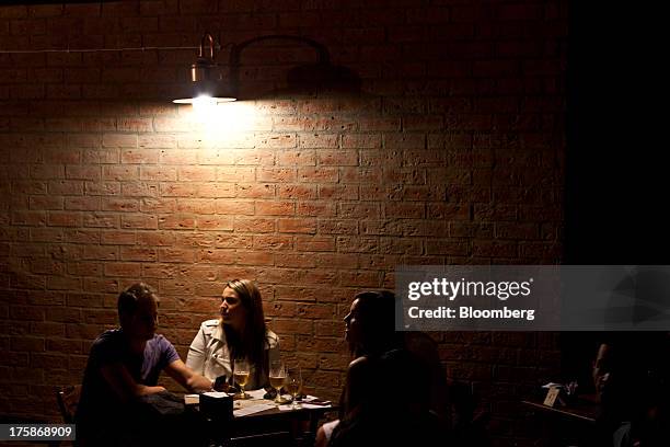 Patrons drink Cia. De Bebidas das Americas Bohemia brand beer at a restored Bohemia brewery in Petropolis, Brazil, Sunday, Aug. 4, 2013. Investors...
