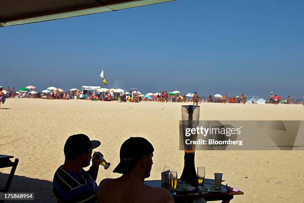 Two men drink beer at the Copacabana beach in Rio de Janeiro, Brazil, on Saturday, Aug. 4, 2013. Investors are betting on billionaire Jorge Paulo...