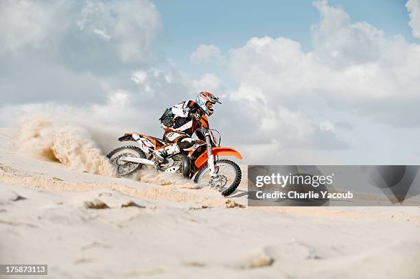 motor cross riding over sand - motocross photos et images de collection