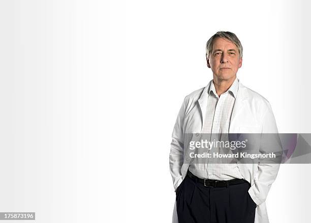senior male doctor standing - gray shirt stock pictures, royalty-free photos & images