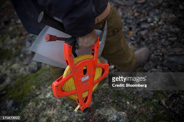 Geologist holds a measuring tape at a Century Iron Mines Corp. Mapping and prospecting site near Schefferville, Quebec, Canada, on Tuesday, Aug. 6,...