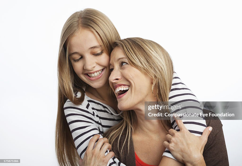 Close up of smiling daughter hugging mother