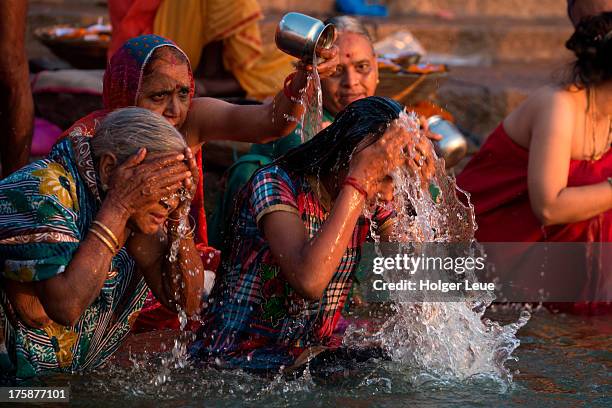 women bathe and pray in water of ganges river - rio ganges imagens e fotografias de stock