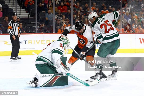 Sean Couturier of the Philadelphia Flyers shoots between Filip Gustavsson and Jonas Brodin of the Minnesota Wild d2n at Wells Fargo Center on October...