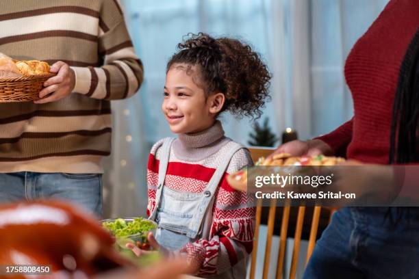 multi-ethnic big family celebrating christmas party together in house. attractive diverse group of people having dinner eating food to celebrate holiday thanksgiving, x-mas eve on dining table at home - african-american-family-thanksgiving stock pictures, royalty-free photos & images