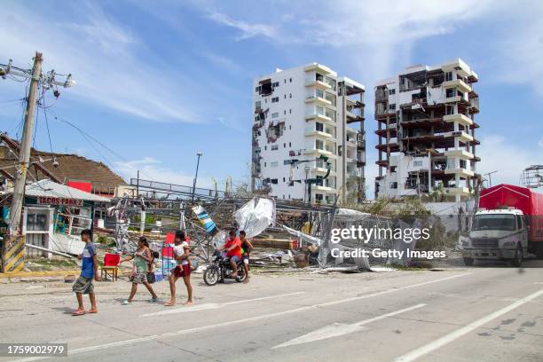 People walk near two damaged buildings after hurricane Otis hit Acapulco on October 26, 2023 in Acapulco, Mexico. Otis made landfall through the...