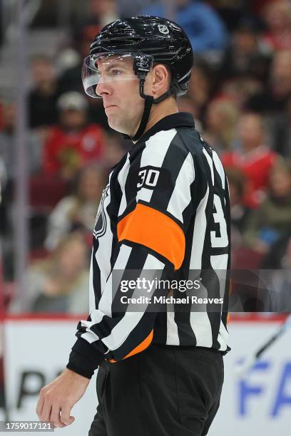 Referee Kendrick Nicholson looks on during the first period between the Chicago Blackhawks and the Boston Bruins at the United Center on October 24,...