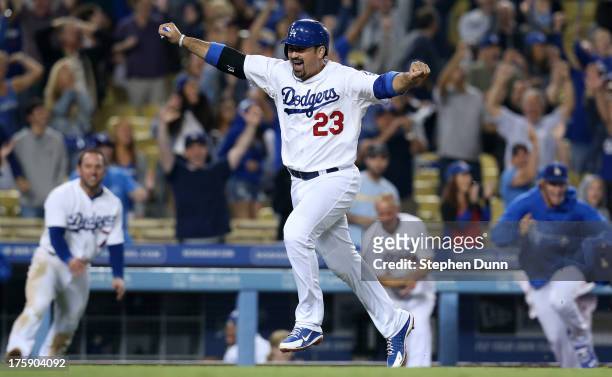 Adrian Gonzalez of the Los Angeles Dodgers celebrates as he runs home to score the winning run in the ninth inning against the Tampa Bay Rays at...