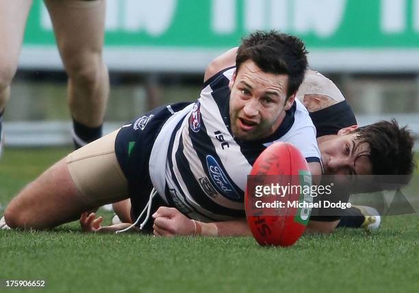 Jimmy Bartel of the Cats gets tackled by Angus Monfries of Port Adelaide during the round 20 AFL match between the Geelong Cats and the Adelaide...