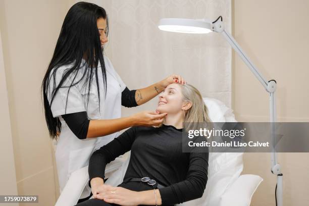a beautician observes the patient before applying a corrector treatment of eyebrows - durability stock pictures, royalty-free photos & images