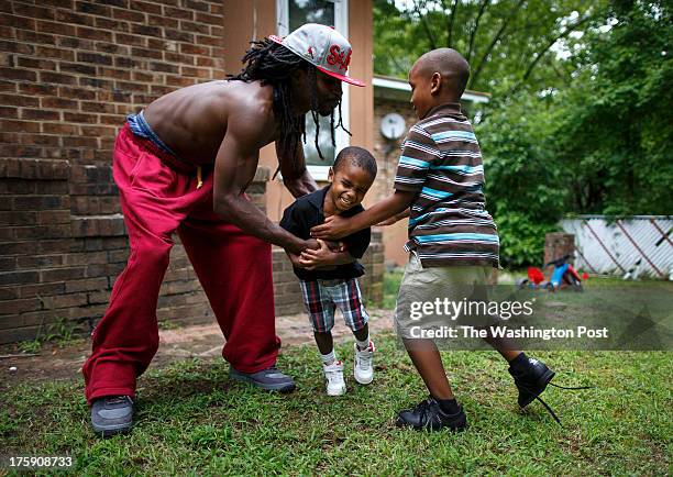 Greensboro, NC - August 7 - Noah Amerson, left, plays football with his sons Micah Amerson, 3 and Malikah Pon at his home in Greensboro, NC on...