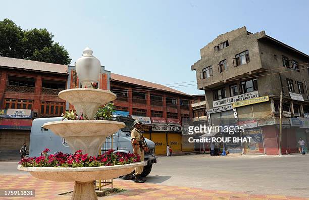 An Indian paramilitary trooper stands guard during a strike in Srinagar on August 10, 2013. A town in the south of Indian Kashmir was under curfew...