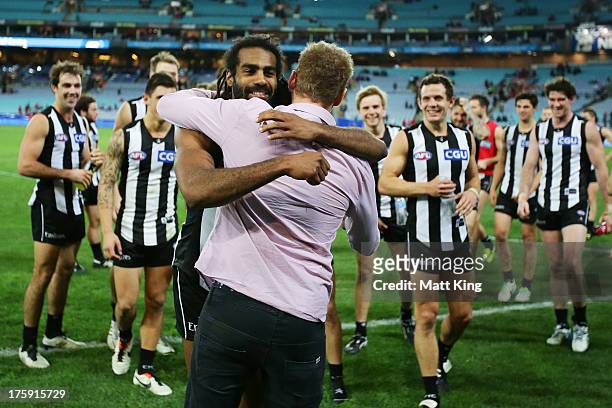 Harry O'Brien of the Magpies embraces retired Collingwood player Ben Johnson following victory in the round 20 AFL match between the Sydney Swans and...