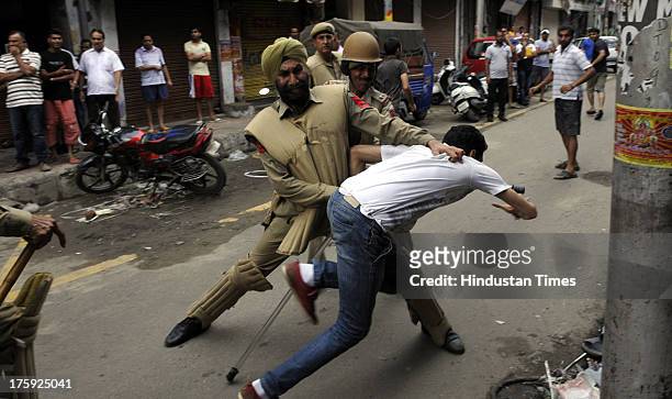Police Personnel trying to stop protestors during a protest over riots in Kishtwar town on August 10, 2013 in Jammu, India. A town in the south of...