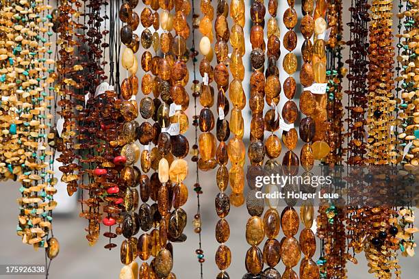 amber necklaces for sale at market stand - bernstein stock-fotos und bilder