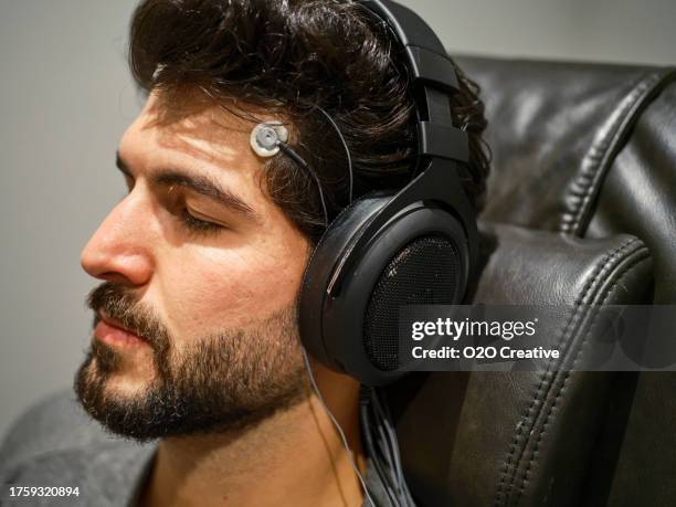 junger mann erhält neurofeedback-behandlung - eeg stock-fotos und bilder