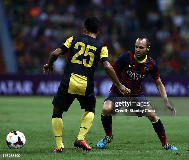 Andres Iniesta of Barcelona FC evades a challenge from Wan Zack of Malaysia during the friendly match between FC Barcelona and Malaysia at Shah Alam...