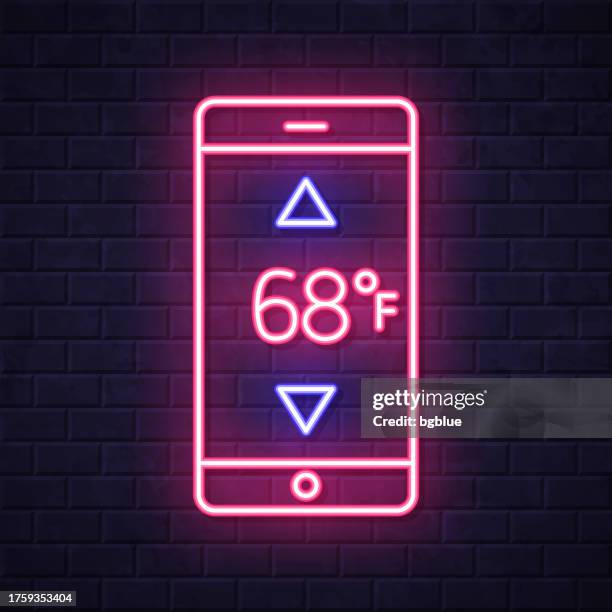smartphone with heating control. glowing neon icon on brick wall background - touch screen wall stock illustrations