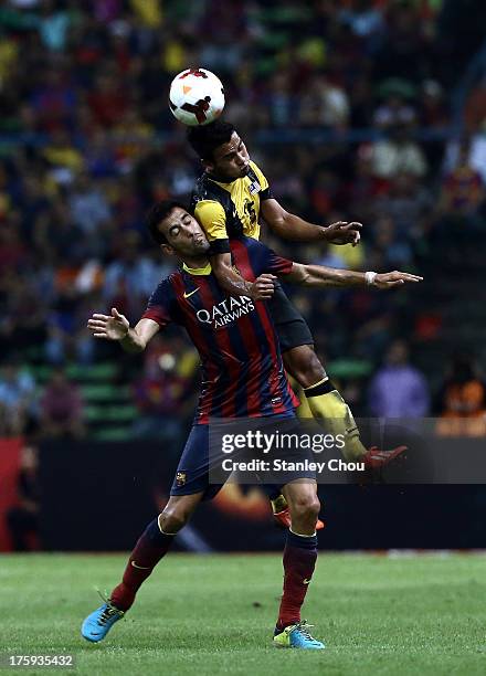 Sergio Busquets of Barcelona FC clashes with Putera Nadher of Malaysia during the friendly match between FC Barcelona and Malaysia at Shah Alam...