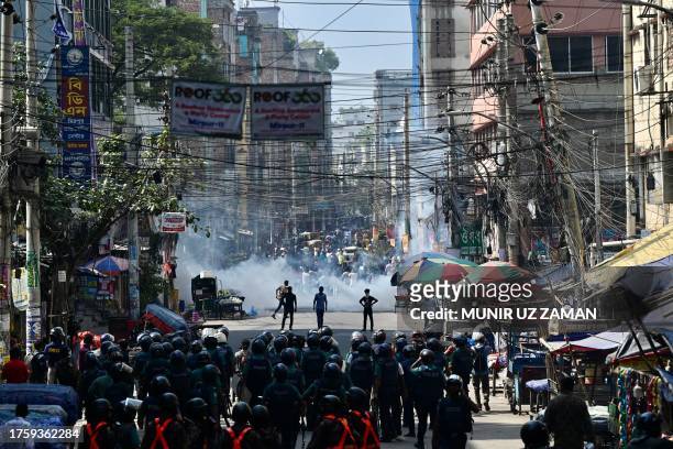 Bangladesh police stand guard along a road during clashes with garment workers protesting to demand the increase of their salaries, in Dhaka on...