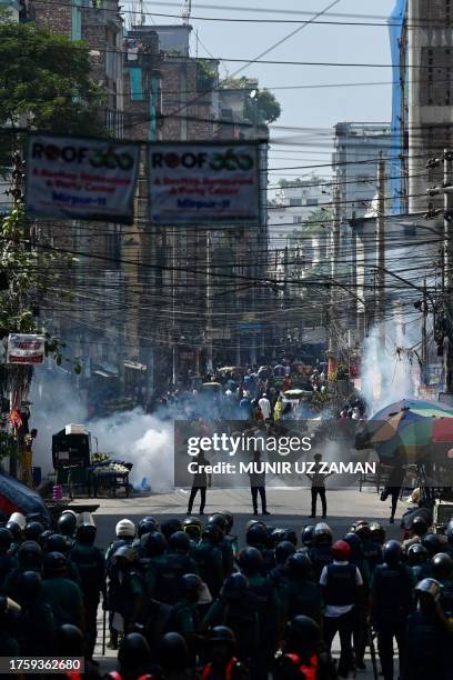 Bangladesh police stand guard along a road during clashes with garment workers protesting to demand the increase of their salaries, in Dhaka on...