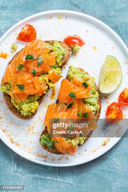 avocado and smoked salmon on toasted bread - fatty acid stock pictures, royalty-free photos & images