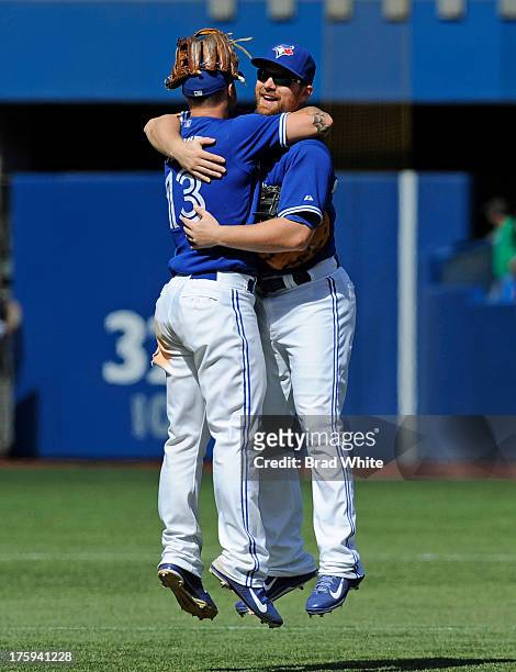 Brett Lawrie and Adam Lind of the Toronto Blue Jays celebrate the teams win over the Oakland Athletics during MLB game action August 10, 2013 at...